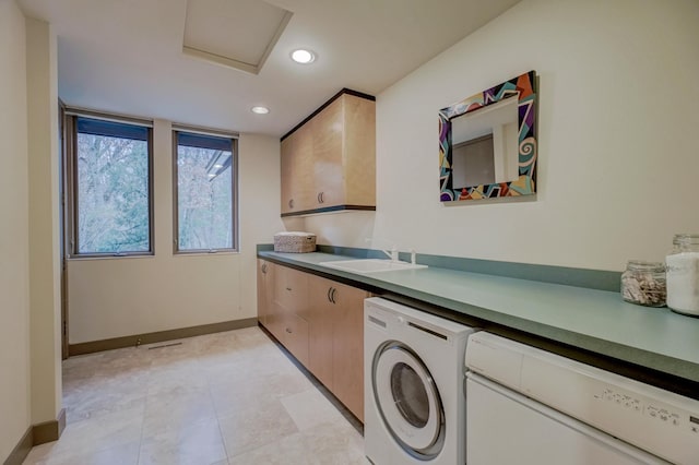 clothes washing area with cabinets, washer / clothes dryer, and sink