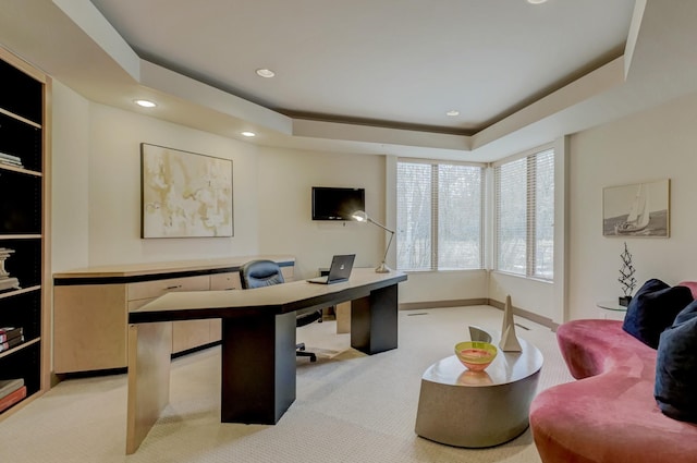 office featuring a raised ceiling and light colored carpet