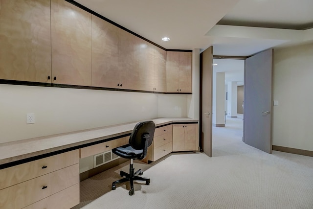 unfurnished office featuring light colored carpet and built in desk