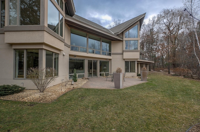 rear view of house with a lawn and a patio