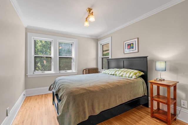 bedroom featuring ornamental molding and light hardwood / wood-style flooring