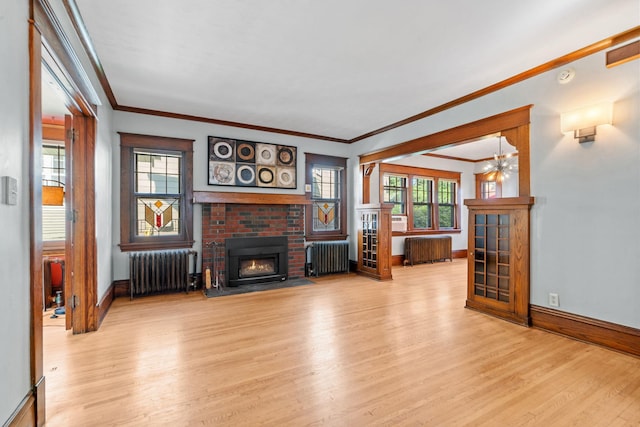 unfurnished living room with light hardwood / wood-style floors, a brick fireplace, and radiator heating unit