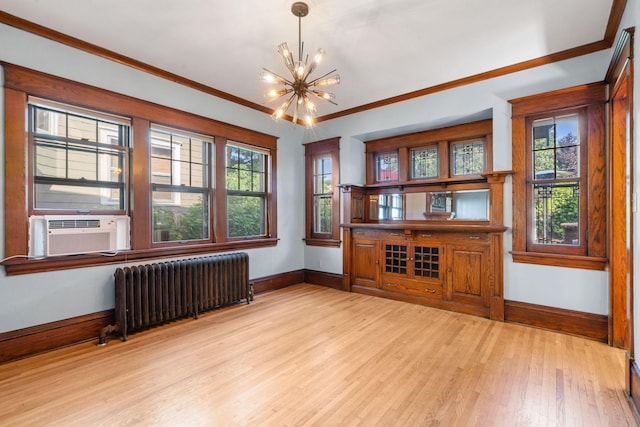 unfurnished room featuring an inviting chandelier, ornamental molding, light hardwood / wood-style flooring, radiator, and cooling unit