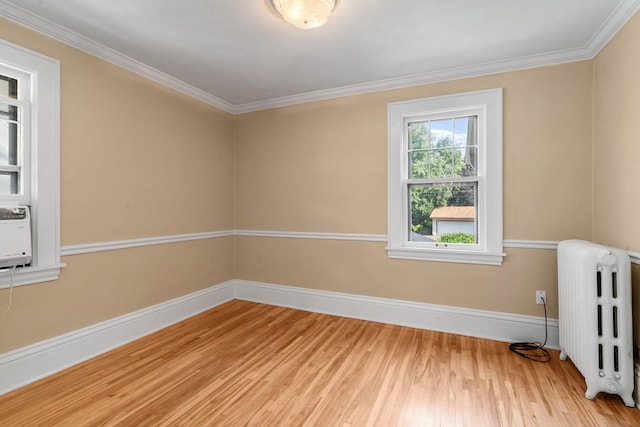 spare room with radiator, wood-type flooring, and crown molding