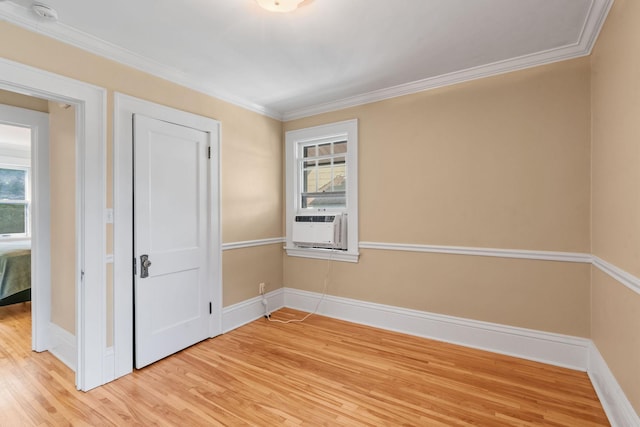 empty room with ornamental molding, cooling unit, wood-type flooring, and plenty of natural light