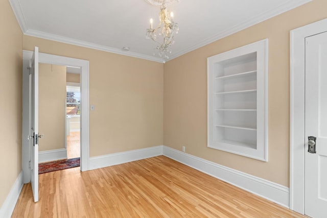 empty room with ornamental molding, a chandelier, hardwood / wood-style flooring, and built in features