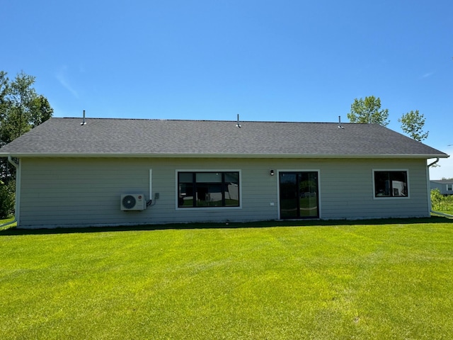 rear view of property featuring a yard and ac unit