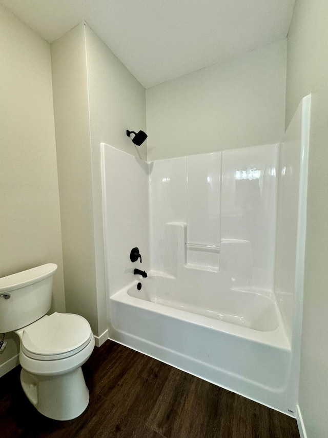 bathroom featuring toilet, bathing tub / shower combination, and hardwood / wood-style flooring