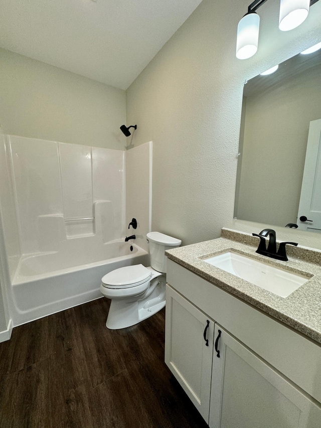 full bathroom with toilet, tub / shower combination, hardwood / wood-style flooring, and vanity