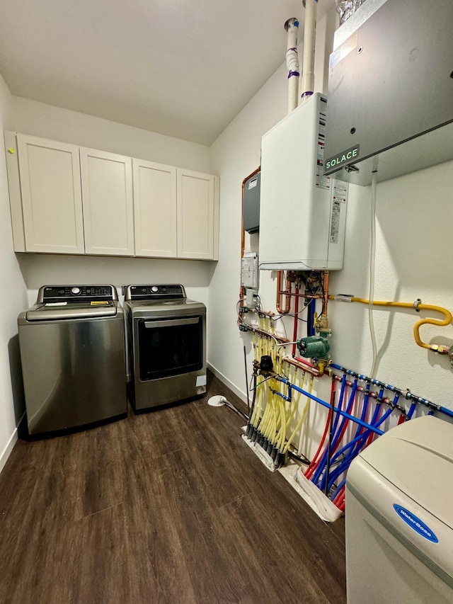 washroom featuring cabinets, dark hardwood / wood-style flooring, tankless water heater, and independent washer and dryer