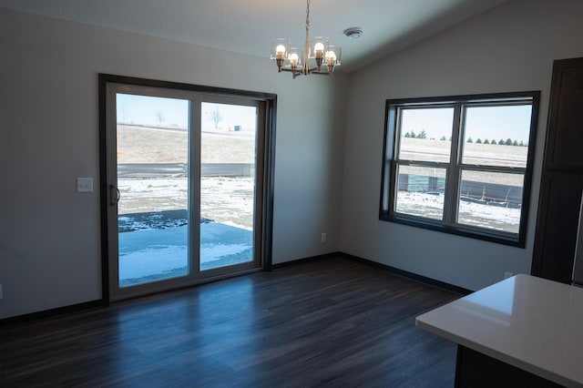 unfurnished dining area featuring lofted ceiling, a notable chandelier, and dark wood-type flooring