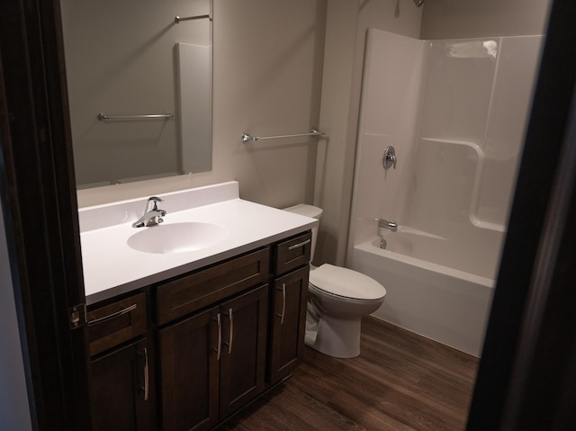 full bathroom featuring wood-type flooring, tub / shower combination, vanity, and toilet