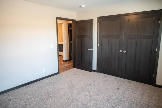 unfurnished bedroom with light colored carpet and a closet