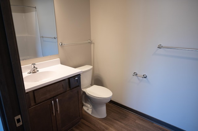 bathroom featuring walk in shower, wood-type flooring, toilet, and vanity