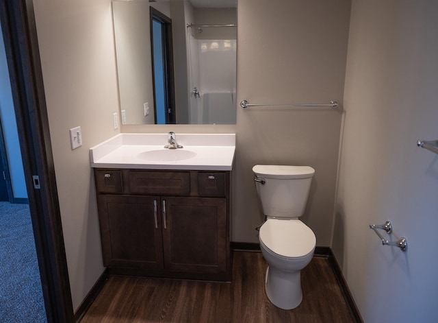 bathroom featuring vanity, hardwood / wood-style flooring, toilet, and walk in shower