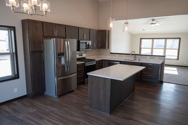 2214 Red Bird Ln, Fairmont, MN 56031 - kitchen featuring appliances with stainless steel finishes, dark brown cabinetry, a high ceiling, a chandelier, and light countertops