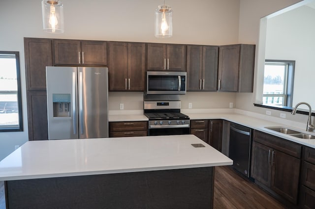2214 Red Bird Ln, Fairmont, MN 56031 - kitchen featuring stainless steel appliances, dark brown cabinets, light countertops, decorative light fixtures, and dark wood-style floors
