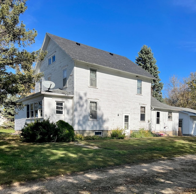 rear view of property featuring a lawn