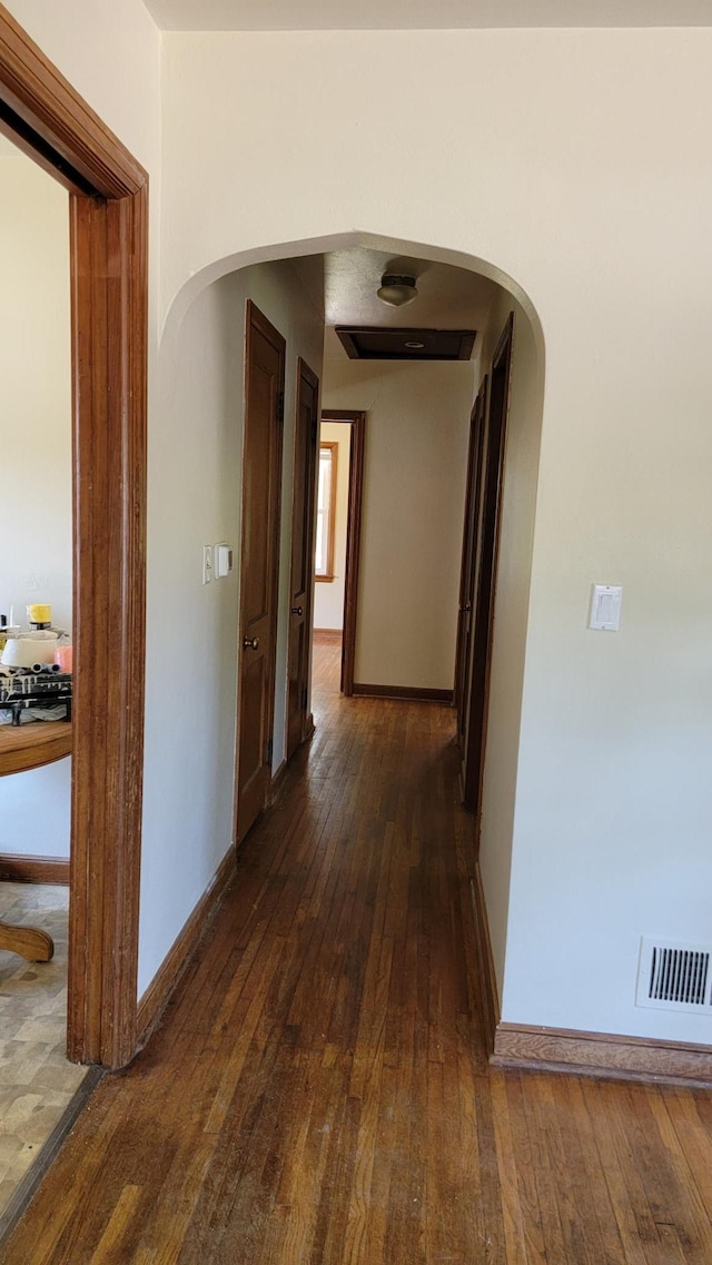 hallway featuring dark tile flooring