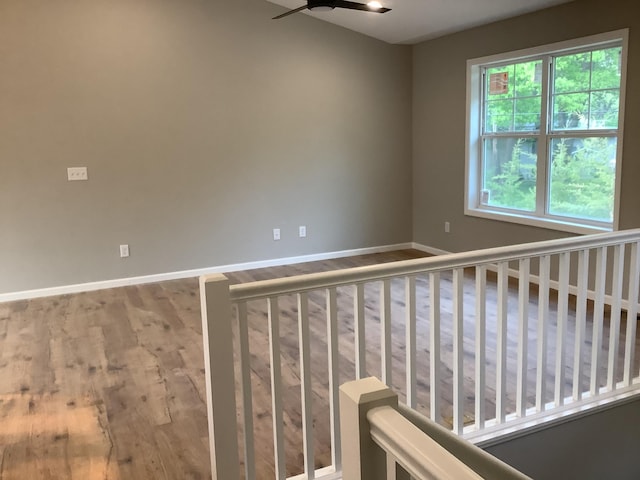 stairs featuring ceiling fan and hardwood / wood-style floors