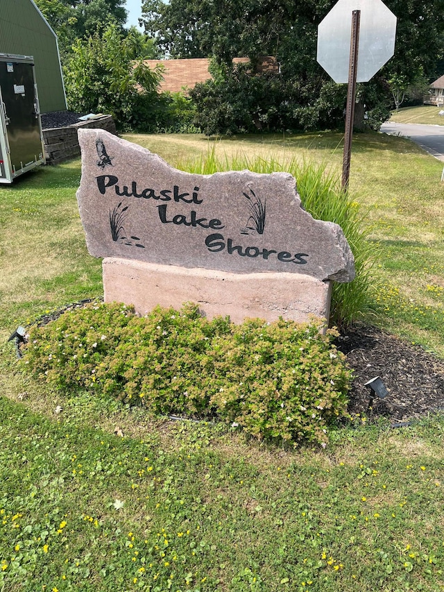 community / neighborhood sign with a lawn