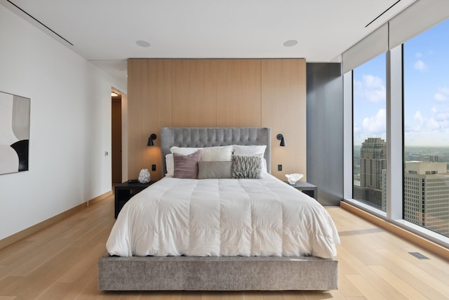 bedroom with light hardwood / wood-style flooring and floor to ceiling windows