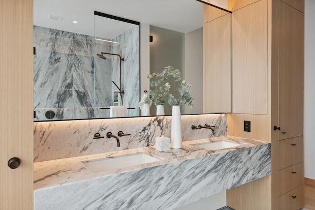 bathroom with vanity and tiled shower