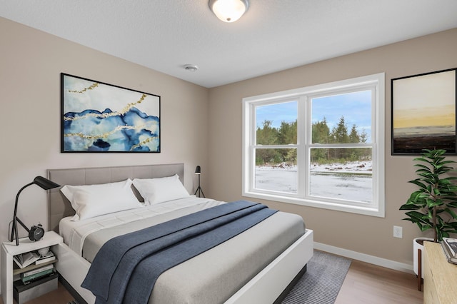 bedroom featuring light hardwood / wood-style flooring and a textured ceiling