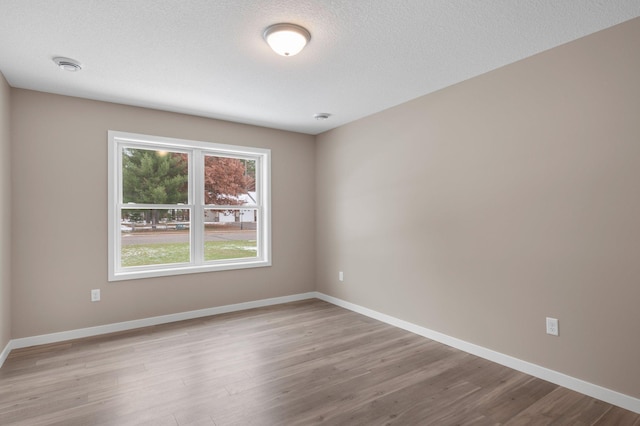 spare room featuring a textured ceiling and light wood-type flooring