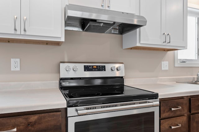 kitchen featuring white cabinetry, dark brown cabinetry, and electric range