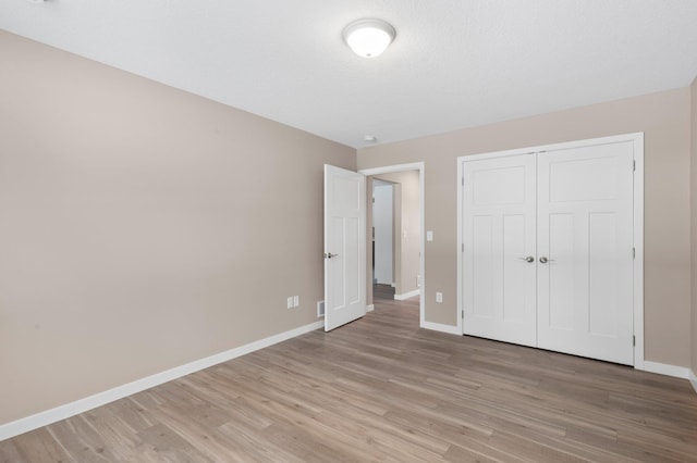 unfurnished bedroom featuring a closet and light hardwood / wood-style flooring