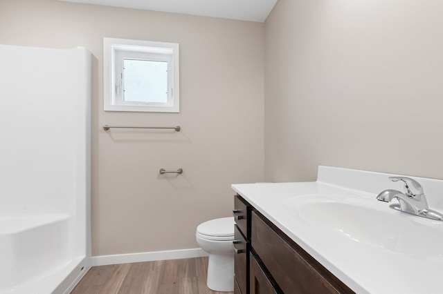 bathroom with toilet, vanity, and hardwood / wood-style flooring