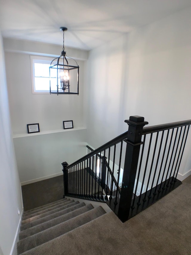 stairs featuring a notable chandelier and carpet floors