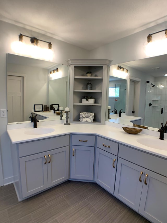 bathroom featuring a shower with door and vanity