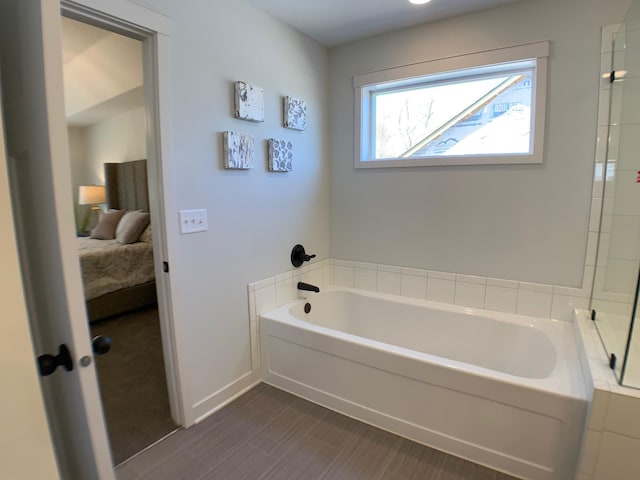 bathroom with a tub and hardwood / wood-style flooring