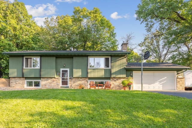 raised ranch featuring a front yard and a garage