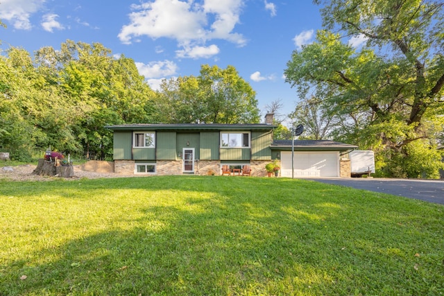 raised ranch featuring a front yard and a garage