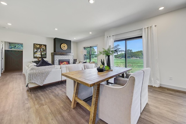 dining area featuring light hardwood / wood-style floors and a tile fireplace