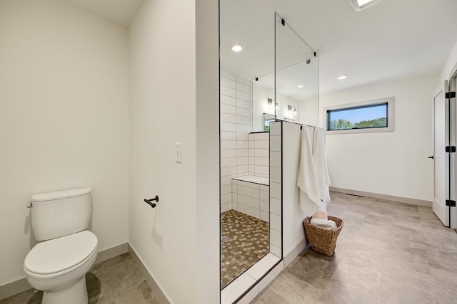 bathroom featuring a tile shower, tile flooring, and toilet