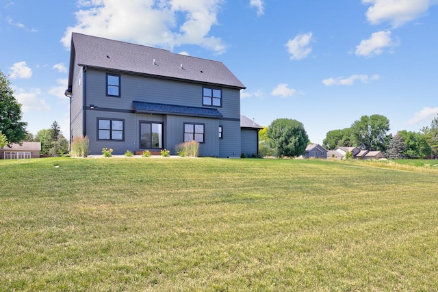 rear view of property featuring a yard