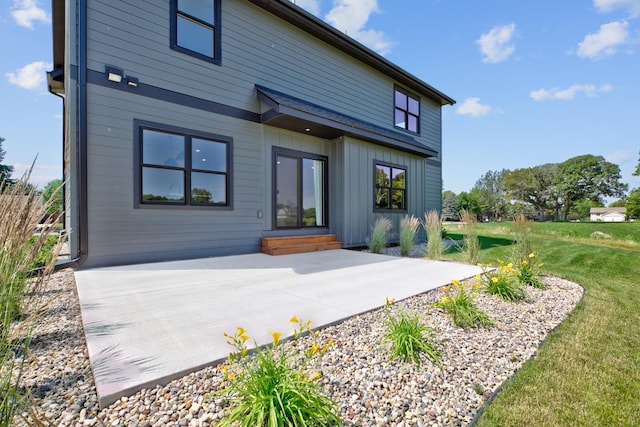 rear view of property with a lawn and a patio