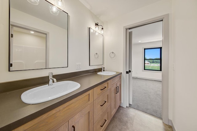 bathroom featuring dual sinks, oversized vanity, and tile flooring