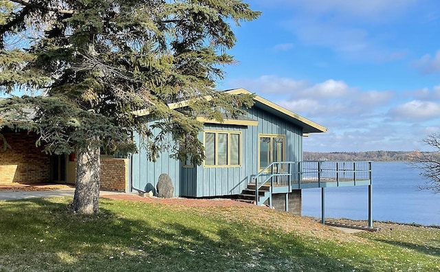 dock area with a lawn and a water view