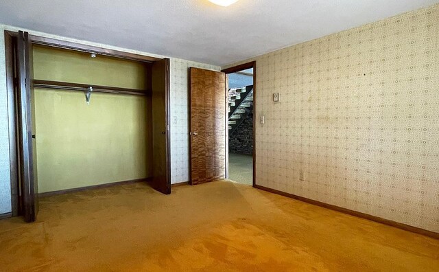 17850 Cedar Park Loop, Fergus Falls, MN 56537 - unfurnished bedroom featuring wallpapered walls, a closet, baseboards, and light carpet
