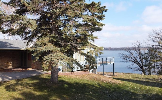 exterior space featuring a water view and a lawn