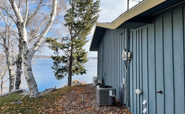 view of property exterior featuring a water view and central AC unit