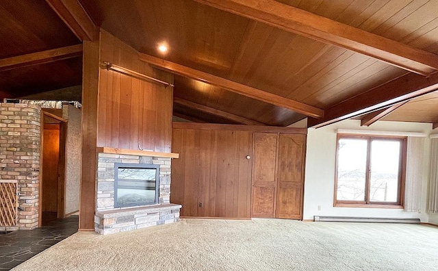 unfurnished living room featuring a fireplace, brick wall, wooden walls, dark carpet, and lofted ceiling with beams