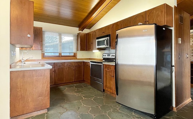 kitchen with vaulted ceiling with beams, wooden ceiling, appliances with stainless steel finishes, dark tile flooring, and sink