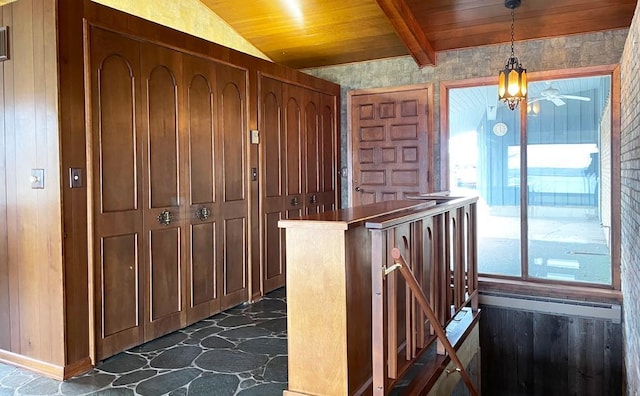 interior space with dark tile flooring, wood ceiling, ceiling fan, and pendant lighting