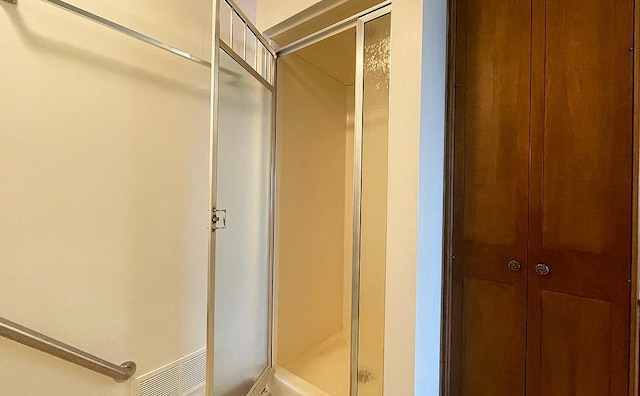 bathroom with a shower with door